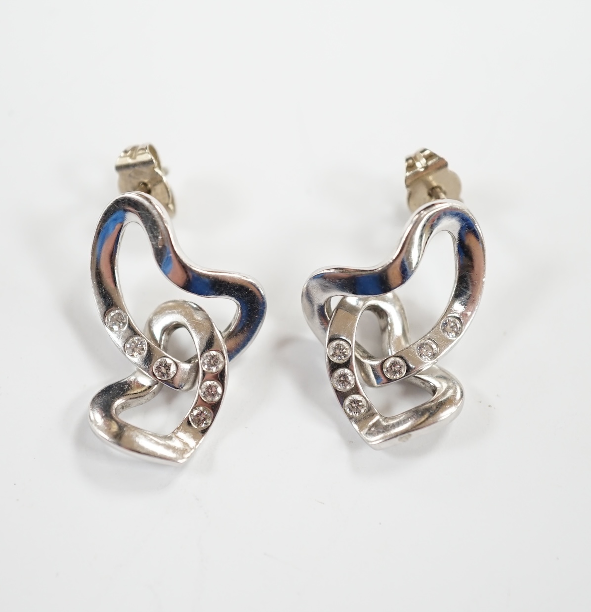 A modern pair of Georg Jensen Danish 750 white metal and diamond chip set drop earrings, or twisted heart form, drop 24mm, gross weight 7.3 grams.